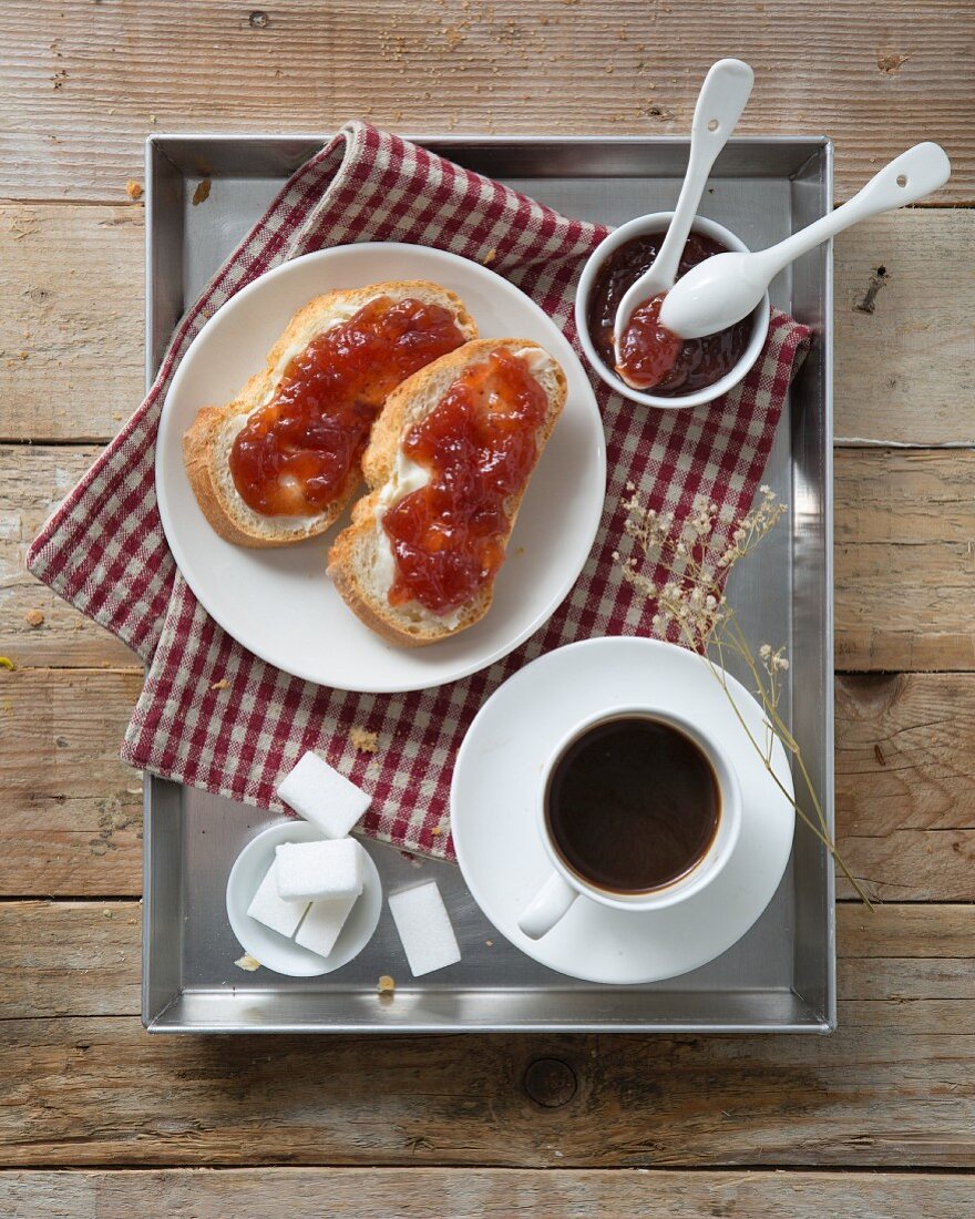 Tasse Kaffee und Marmeladenbrote auf Frühstückstablett (Aufsicht)