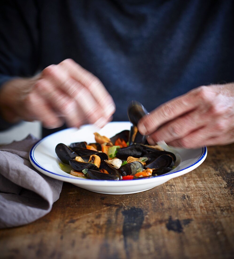 A person eating mussels