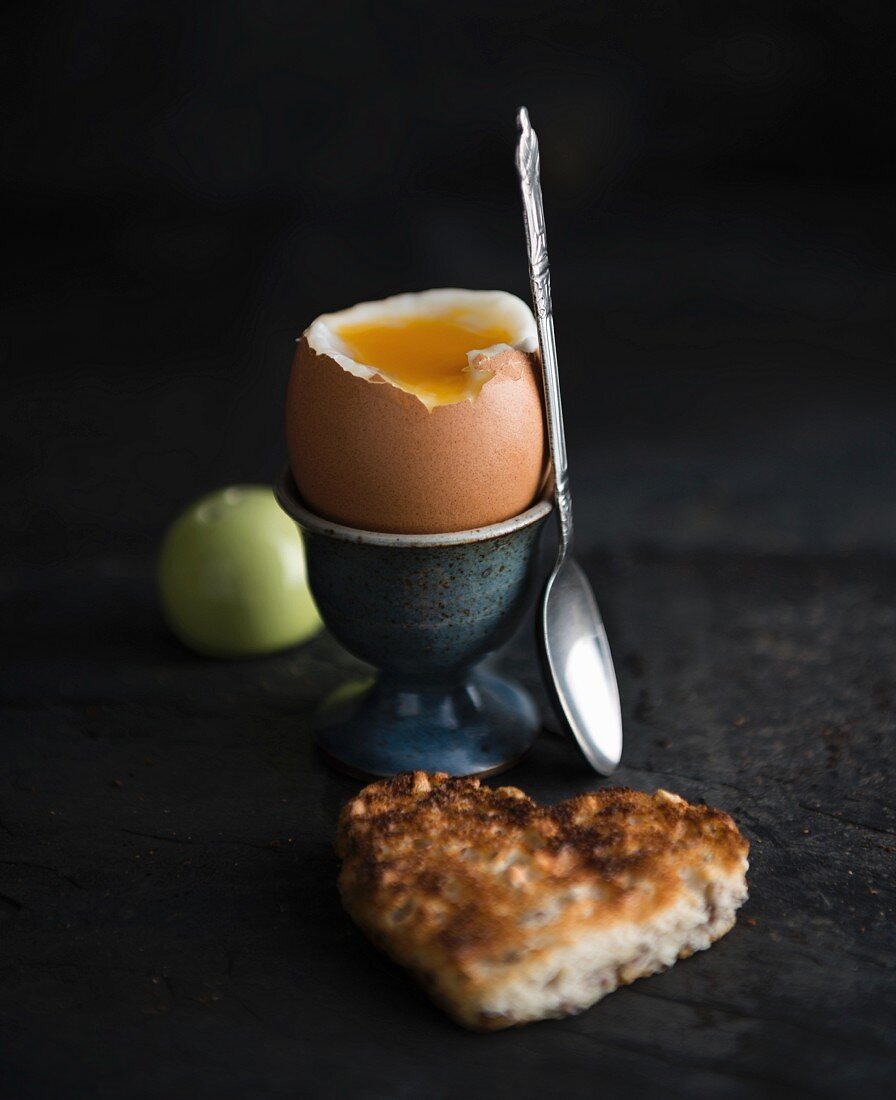 A soft-boiled egg and a piece of heart-shaped toast