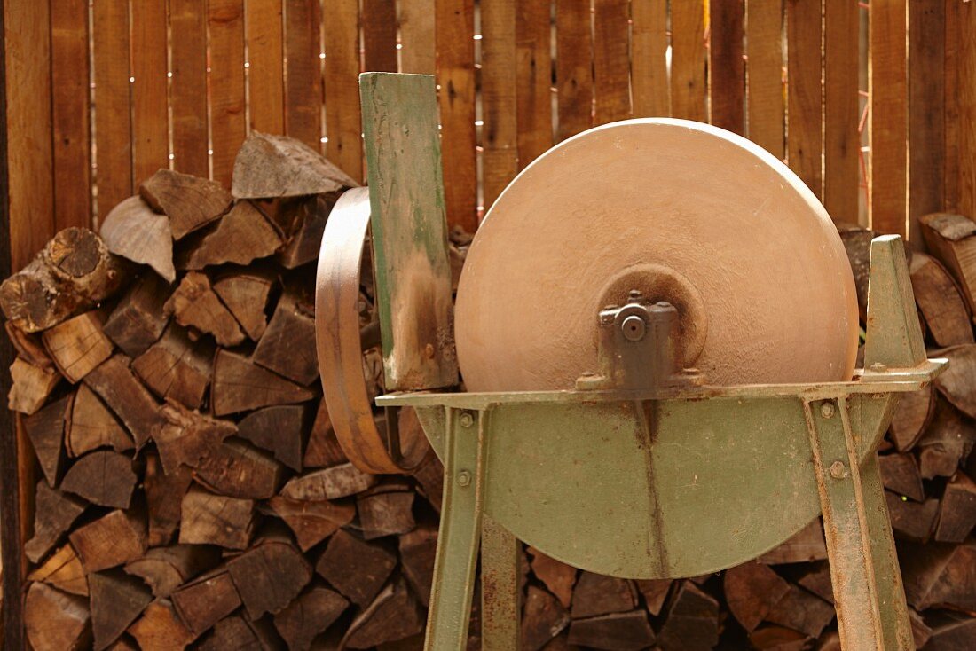A grinding machine in front of a stack of wood