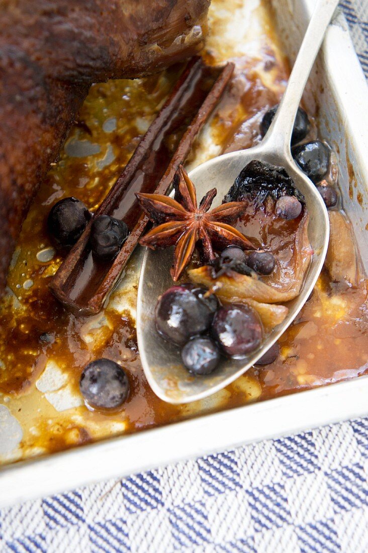 Spoon with gravy, sloes, cinnamon and star anise