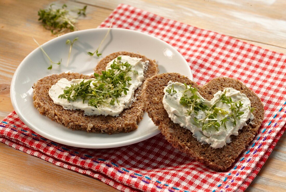 Heart-shaped slices of bread topped with quark and cress