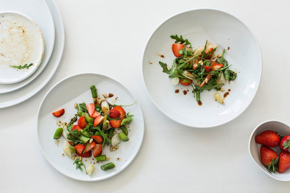 Variations of strawberry and asparagus salad with rocket and green beans