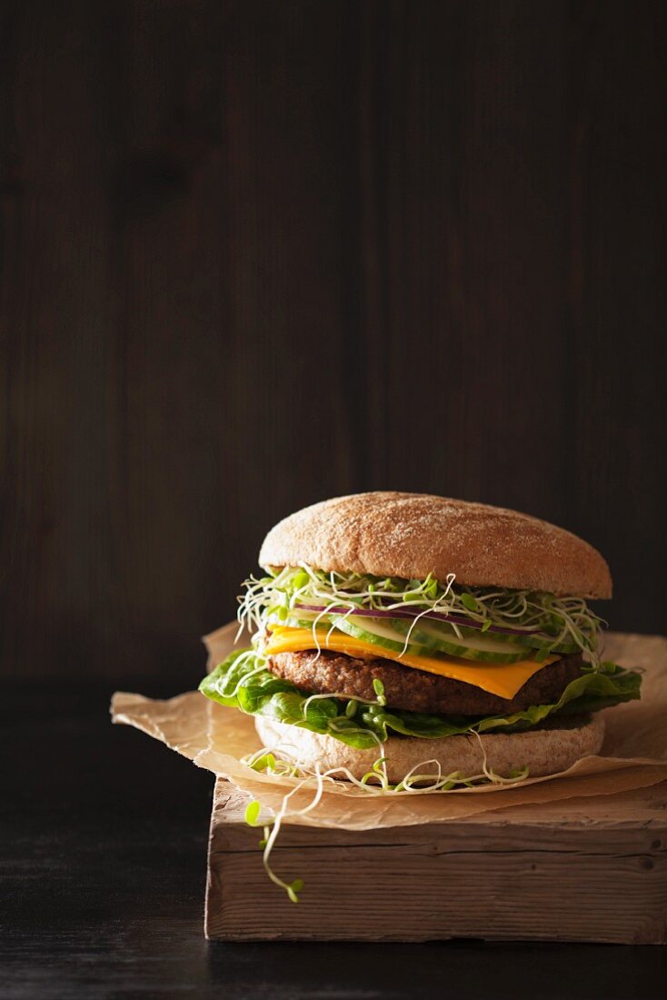 Veganer Hamburger mit Sojabratling, veganem Käseersatz, Gurken und Kleesprossen