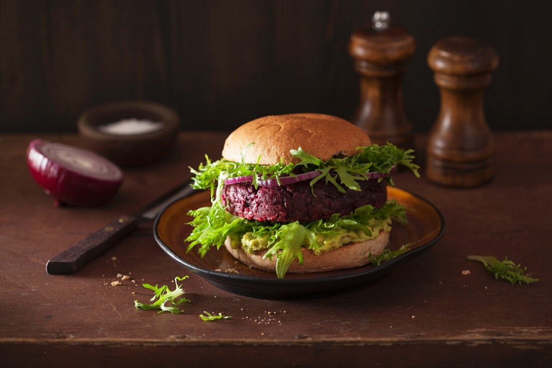 A veggie burger with a beetroot patty and avocado spread