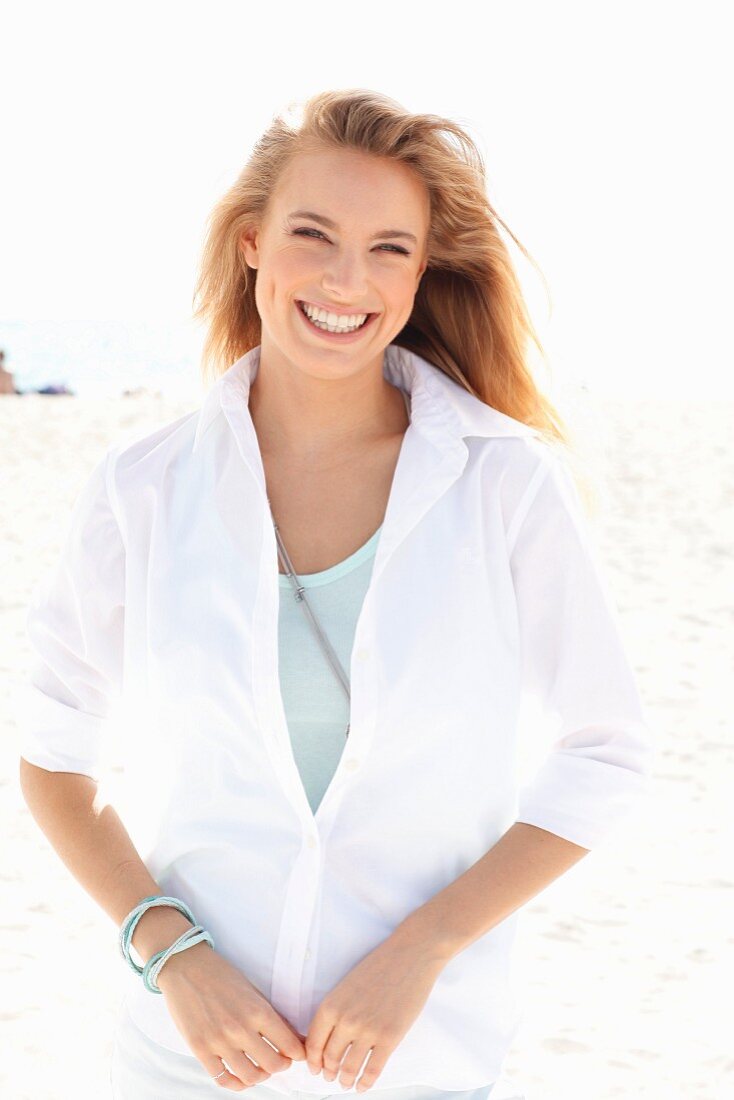 A young blonde woman wearing a white blouse