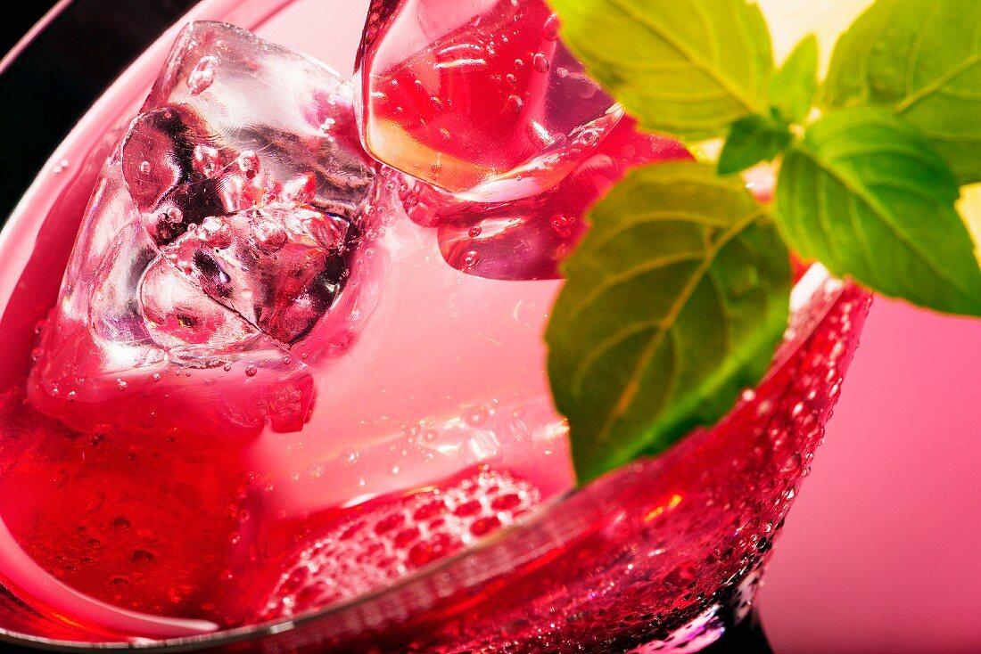 Rosa Cocktail im Glas mit Minze (Close Up)