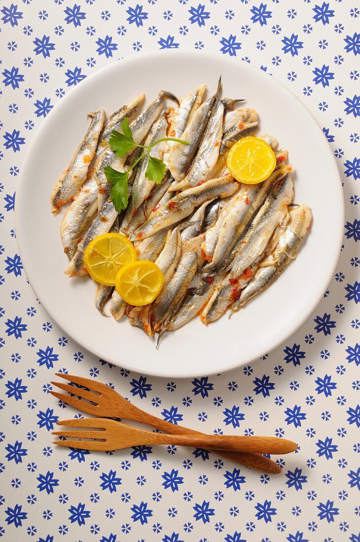 Anchovies with lemon slices on a plate