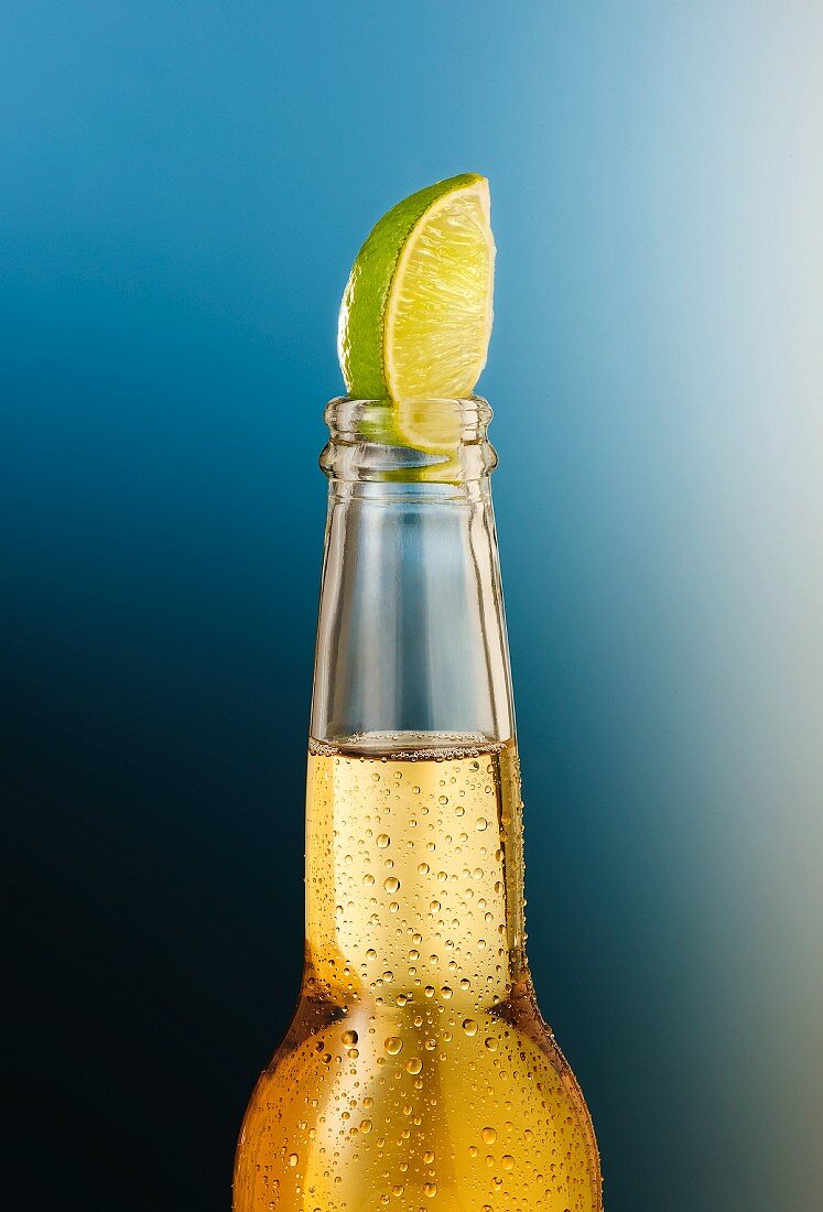A beer bottle with condensation and a lime wedge