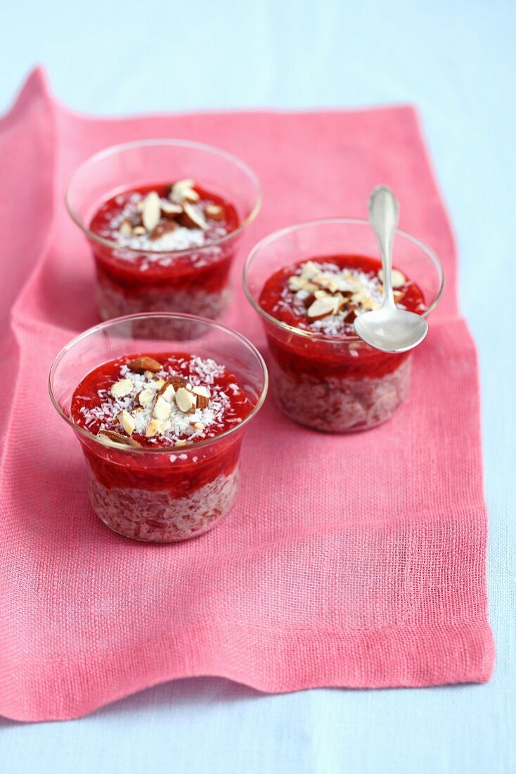 Red rice pudding with strawberry jam, coconut and almonds