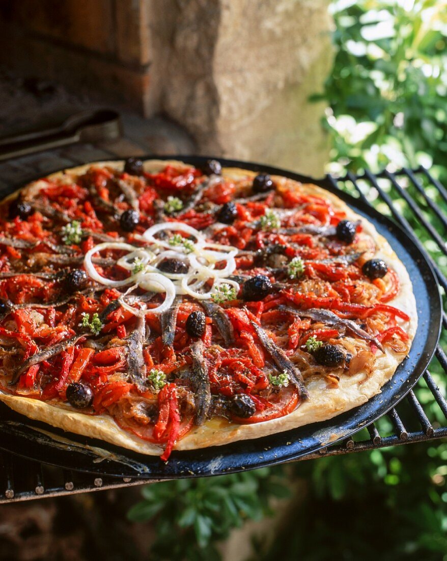 A pizza with peppers, olives and anchovies