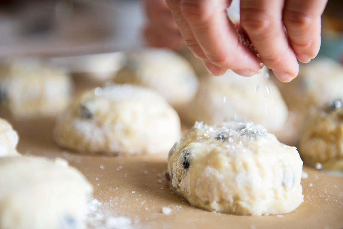 Unbaked scones being sprinkled with sugar
