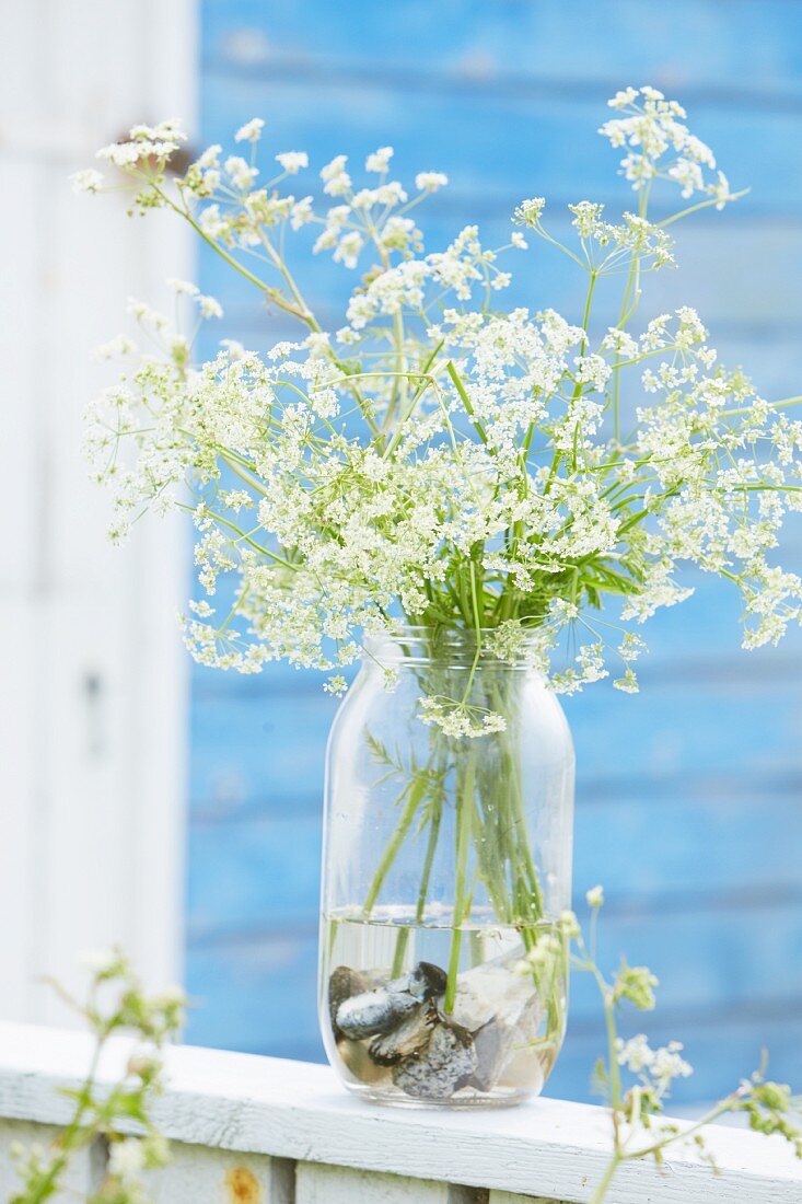 Flowers in preserving-jar vase with pebbles in bottom