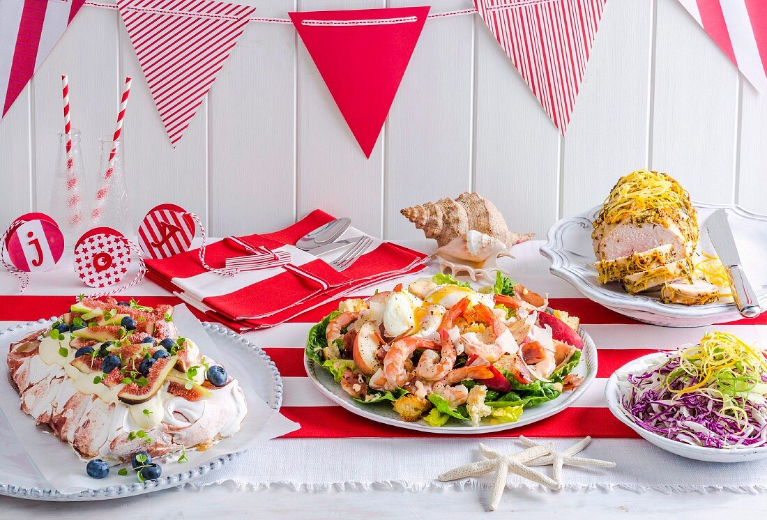 Weihnachtsbuffet mit verschiedenen Gerichten auf rot-weißem Tischläufer