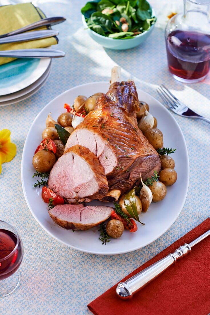Roasted leg of lamb with potatoes, carved