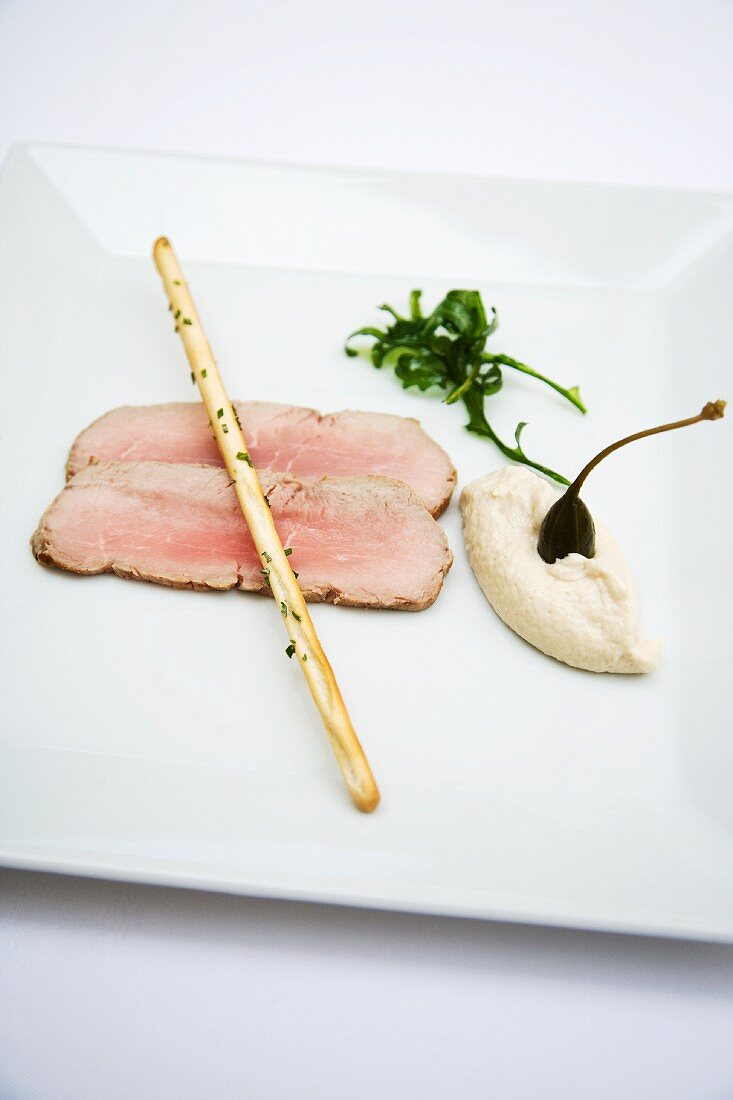 Pink vitello tonnato with grissini