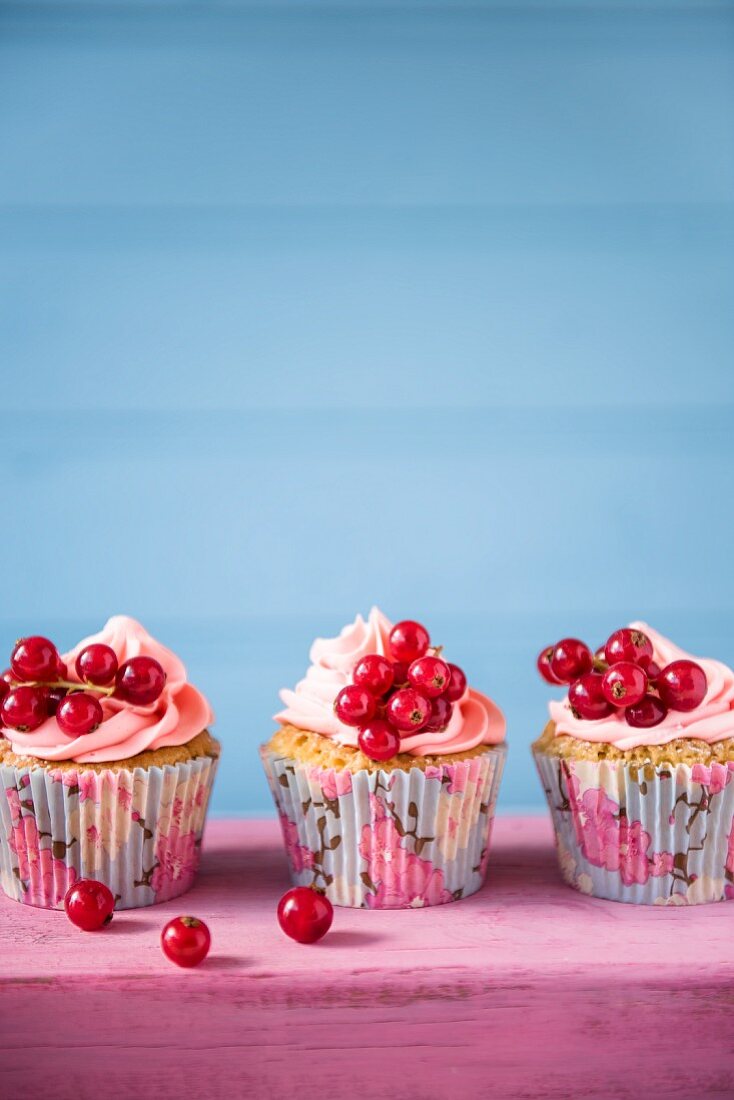 Cupcakes with pink butter cream and redcurrants