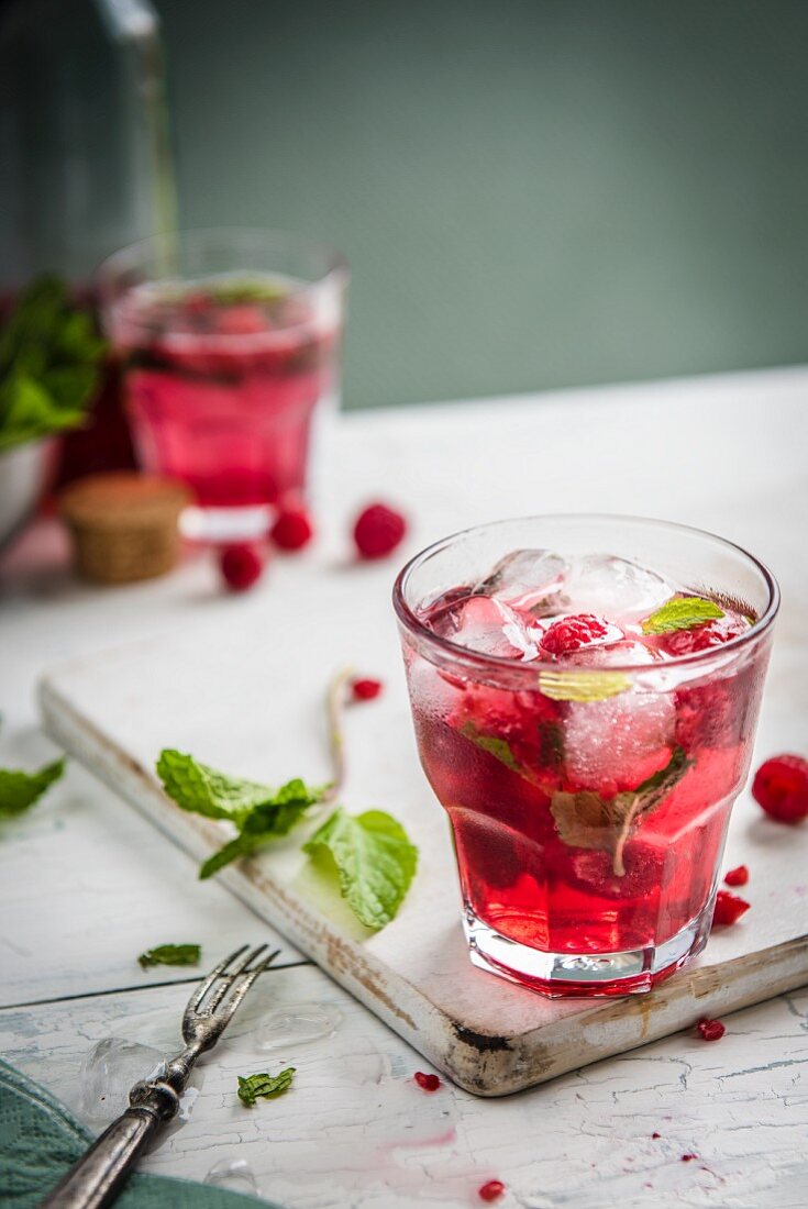 Raspberry lemonade with fresh raspberries, mint and ice cubes