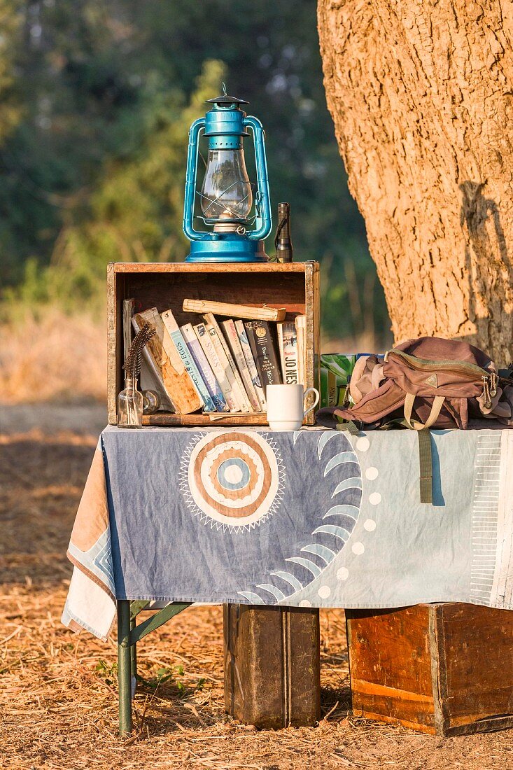 Bücher und Laterne im Camp einer Wandersafari, Sambia, Afrika