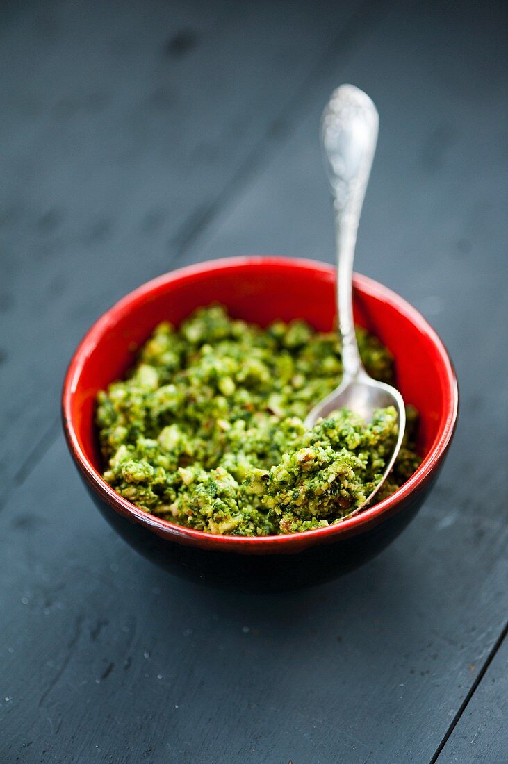 Wild garlic pesto in a red bowl on a wooden surface