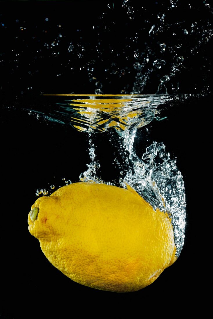 Zitrone fällt ins Wasser mit einem Splash