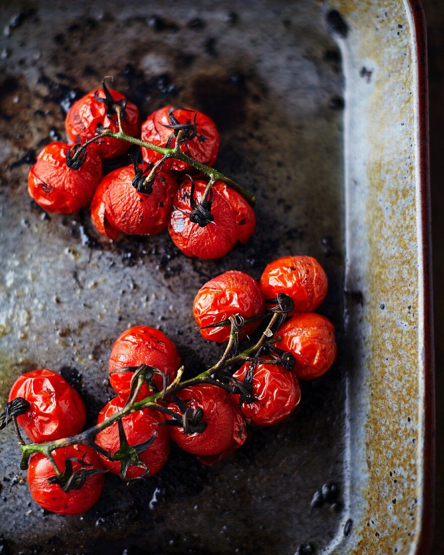 Roasted cherry tomatoes on a baking tray (seen from above)