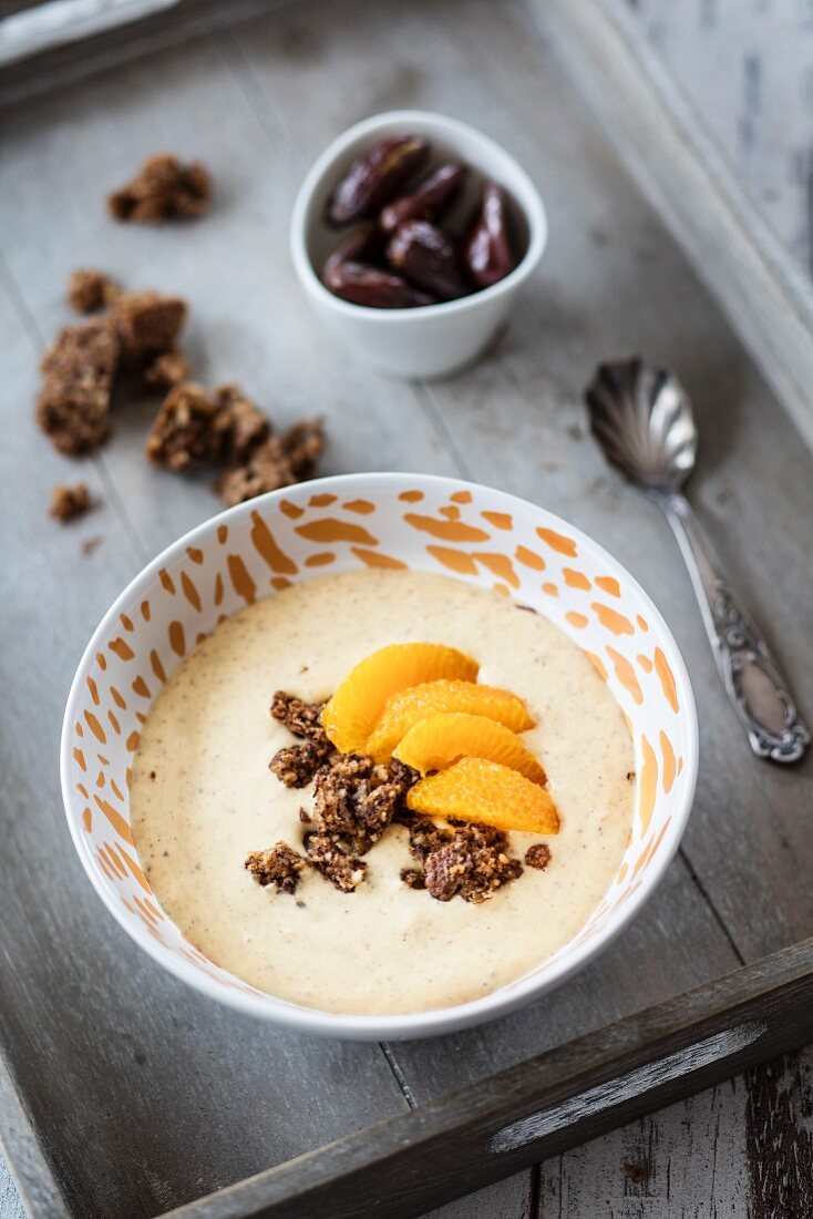 A smoothie bowl with dates, gingerbread and mandarines