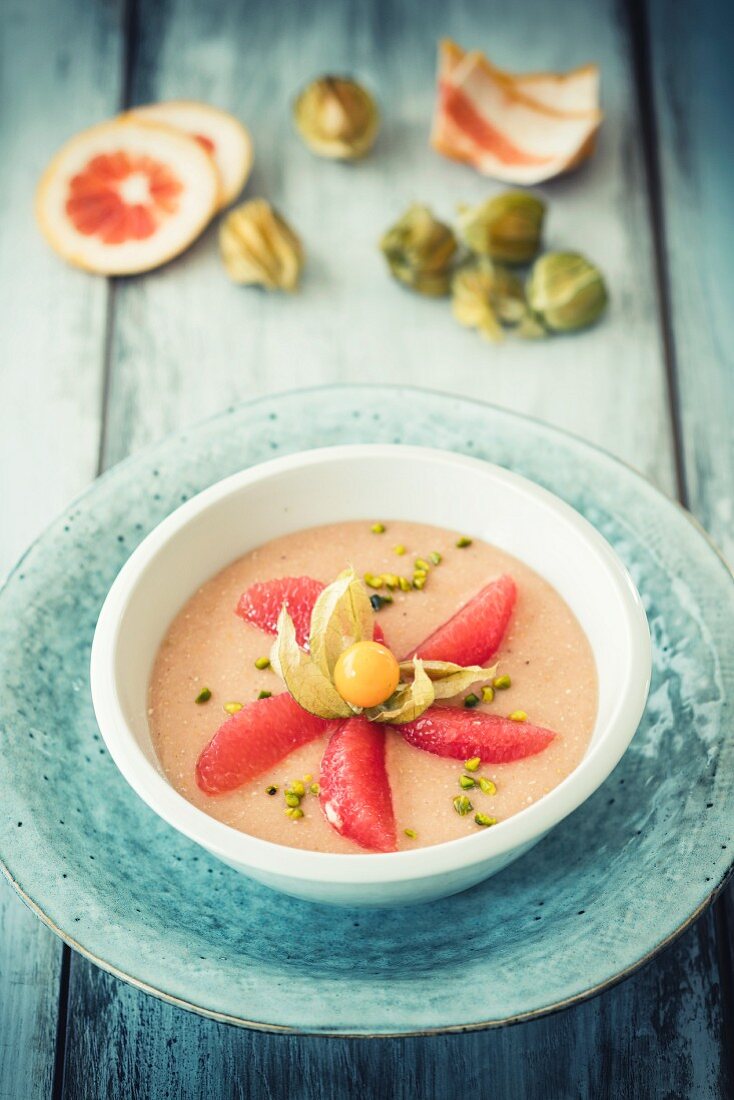 A smoothie bowl wit grapefruit, physalis and pistachios