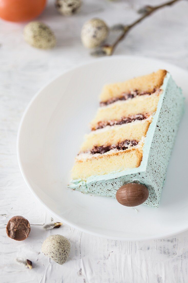A slice of a speckled Easter cake with chocolate eggs