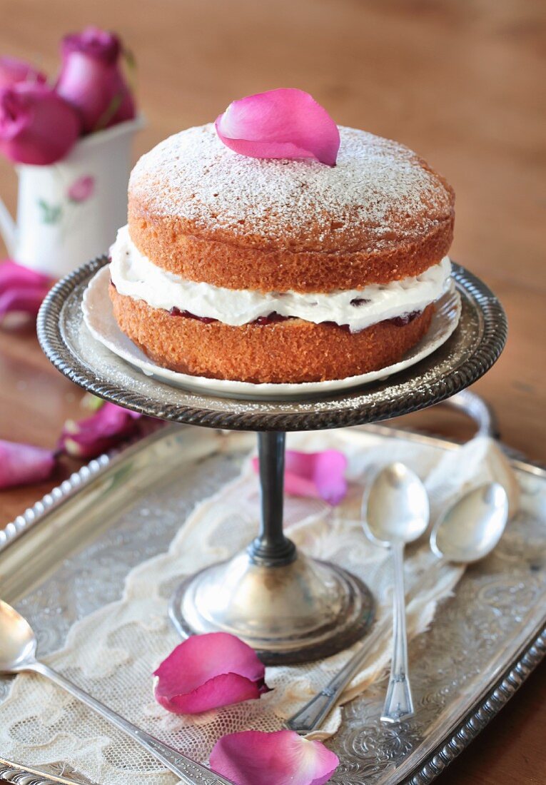 A Victoria Sandwich Cake with berry jam and rose petals