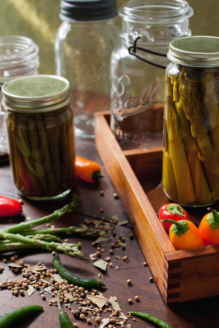 Asparagus, beans and peppers with pickling spices and antique preserving jars
