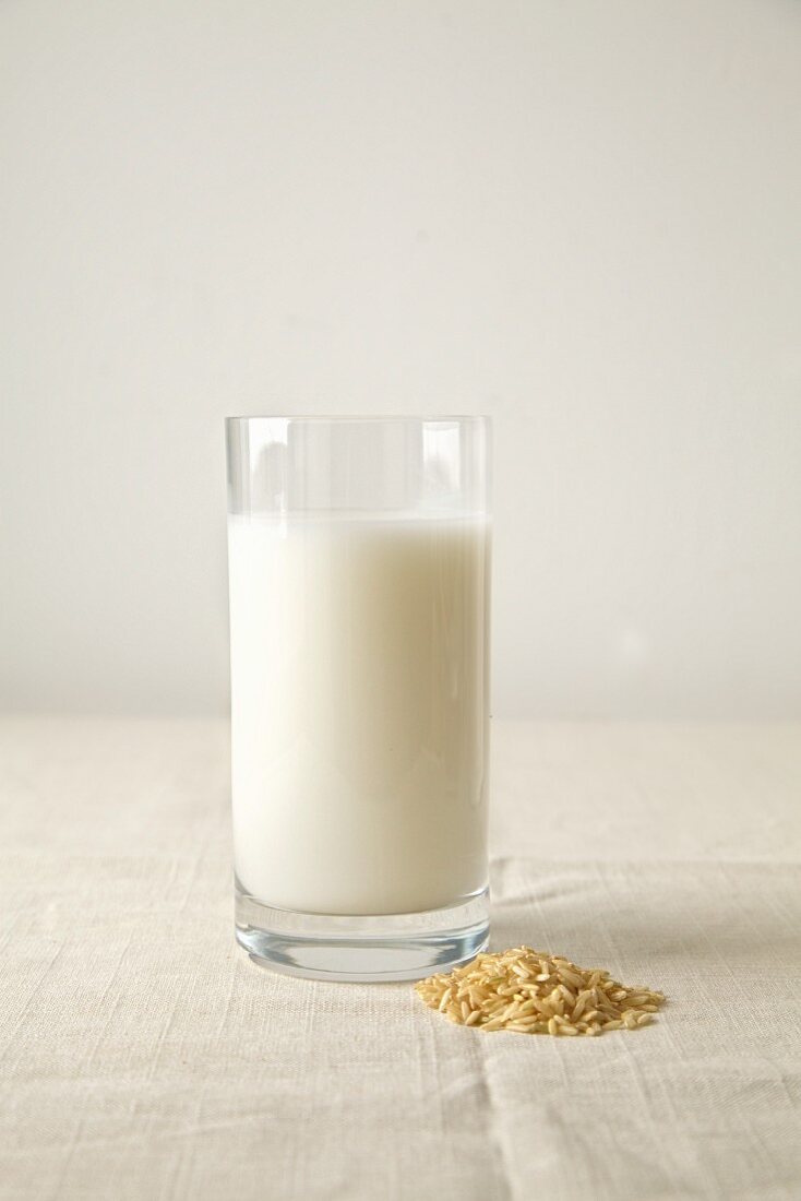 Rice milk in a glass next to rice grains