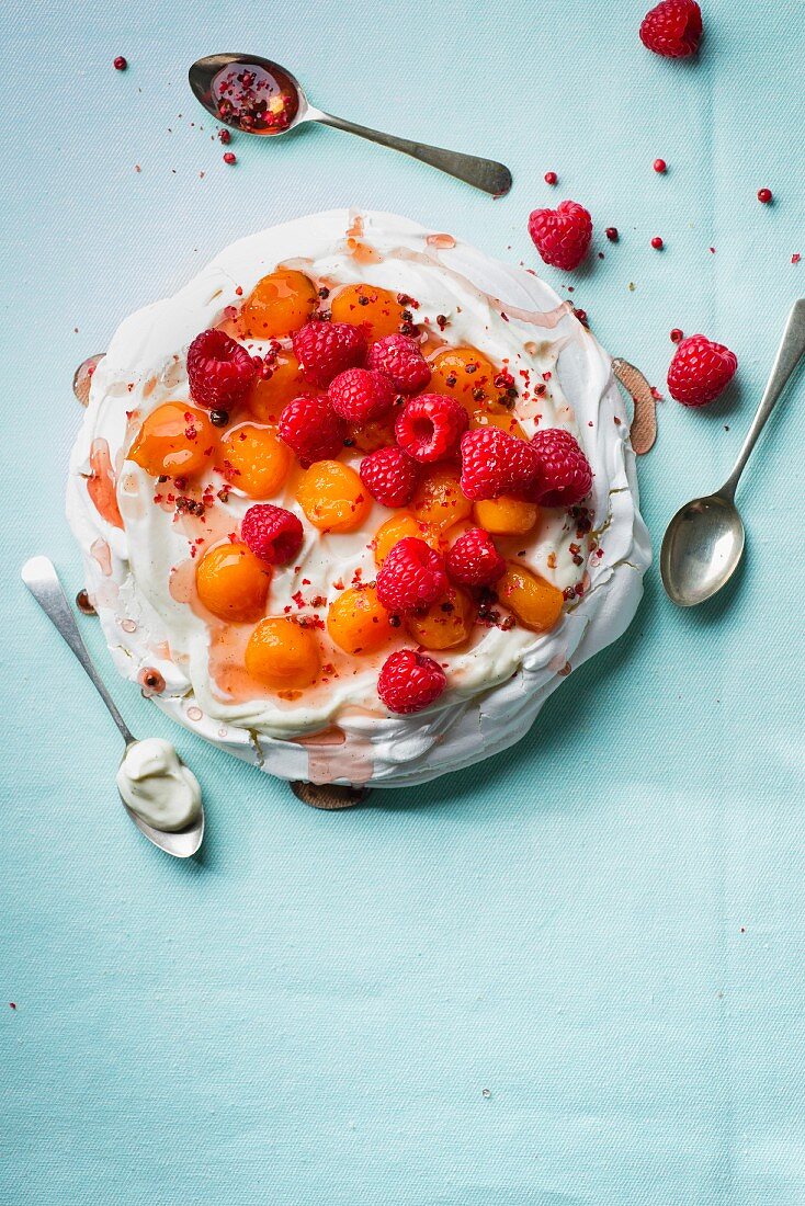 Pavlova mit in Rosé pochierter Wassermelone, Himbeeren, rosa Pfeffer und Vanillejoghurt