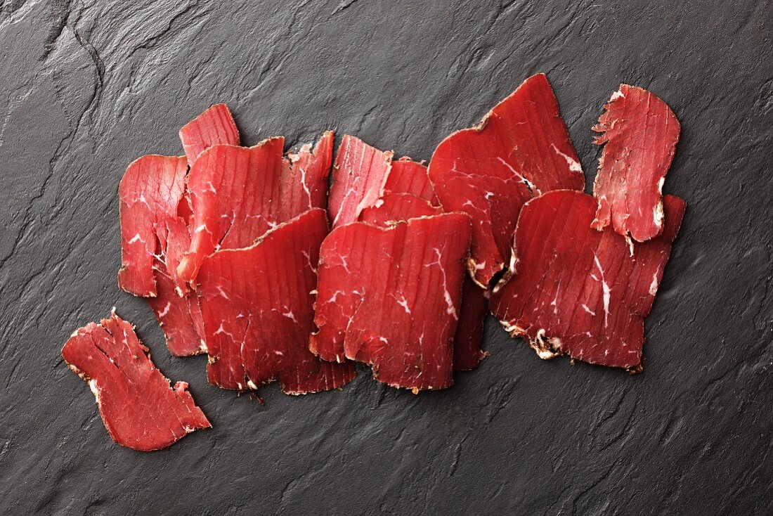 Sliced smoked beef on a slate surface (South Tyrol)