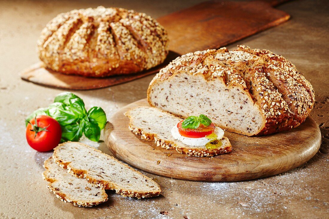 Zwei Laibe Mehrkorn-Quark-Brot mit Tomate, Mozzarella, Basilikum und Olivenöl