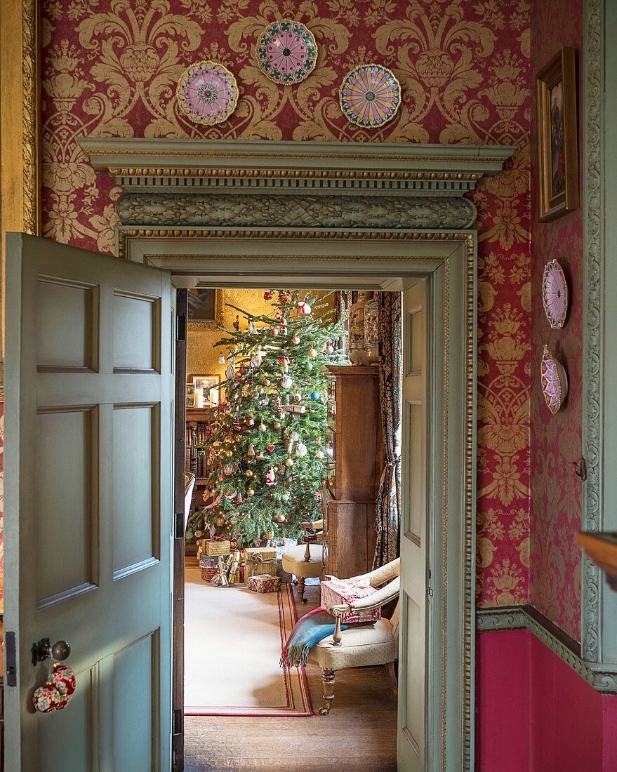 Blick durch antike Tür in weihnachtliches Wohnzimmer