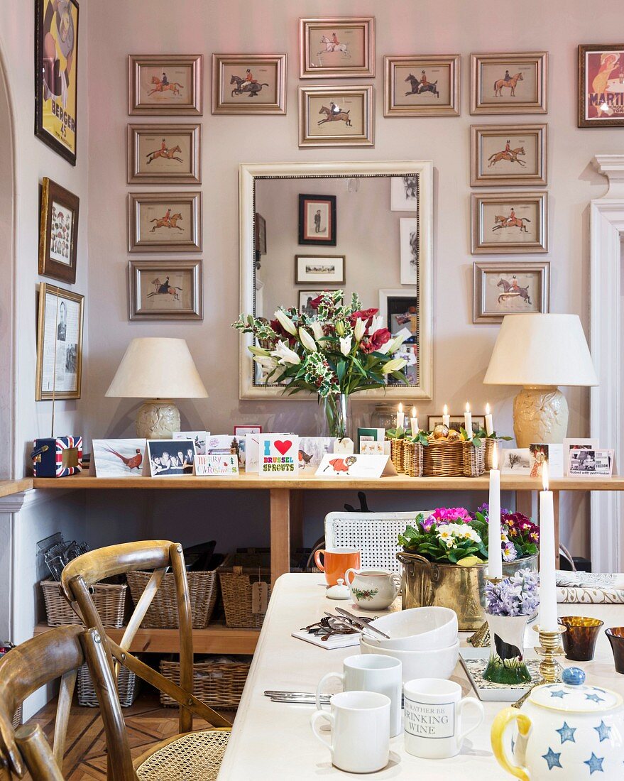 Mirror surrounded by pictures of horses above console table