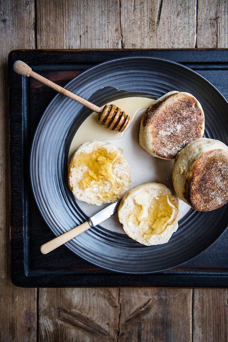 English Muffins mit Honig auf einem Teller (Draufsicht)