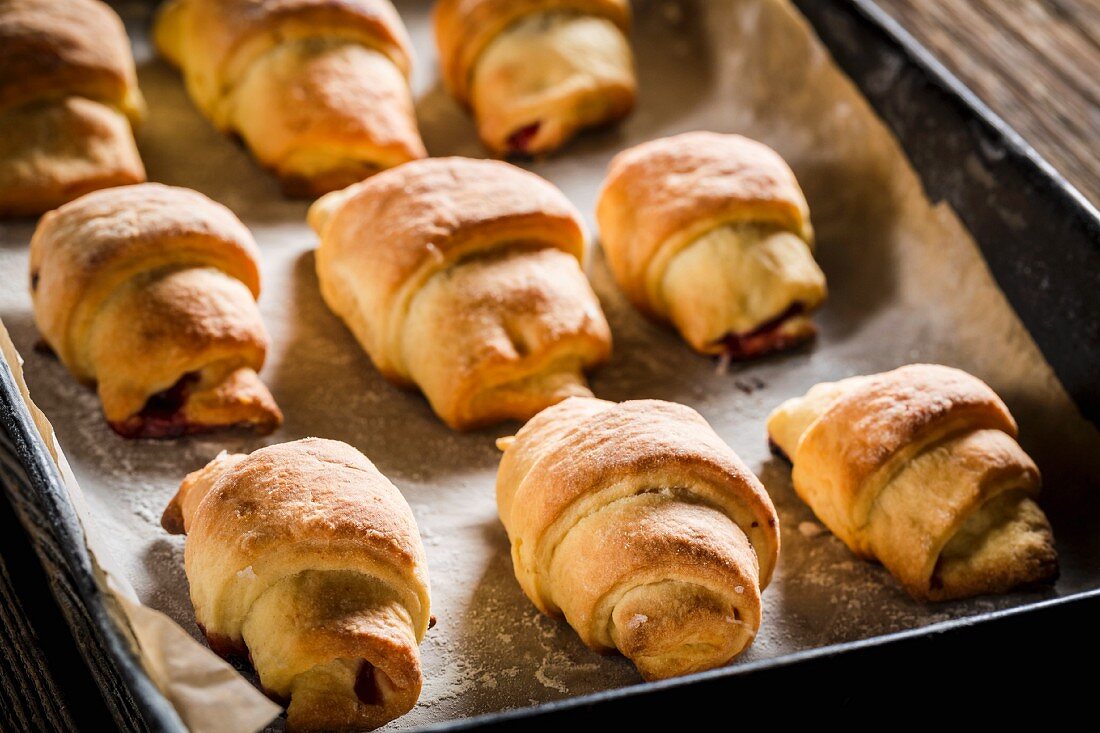 Freshly baked croissants on a baking tray