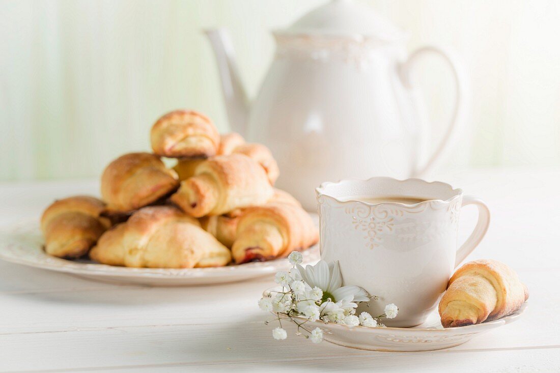 Coffee and croissants on a white table