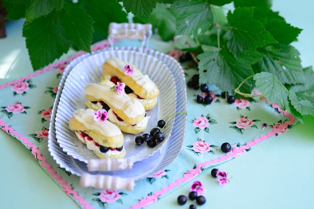 Eclairs with cream and blackcurrants