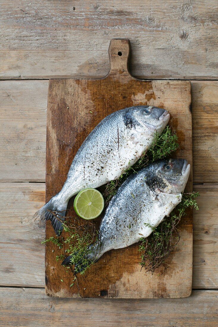 Seabream with herbs and lime on a chopping board