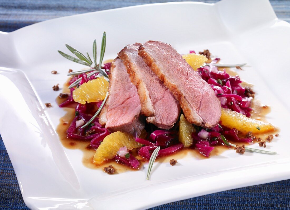 Duck breast on a bed of red cabbage with oranges