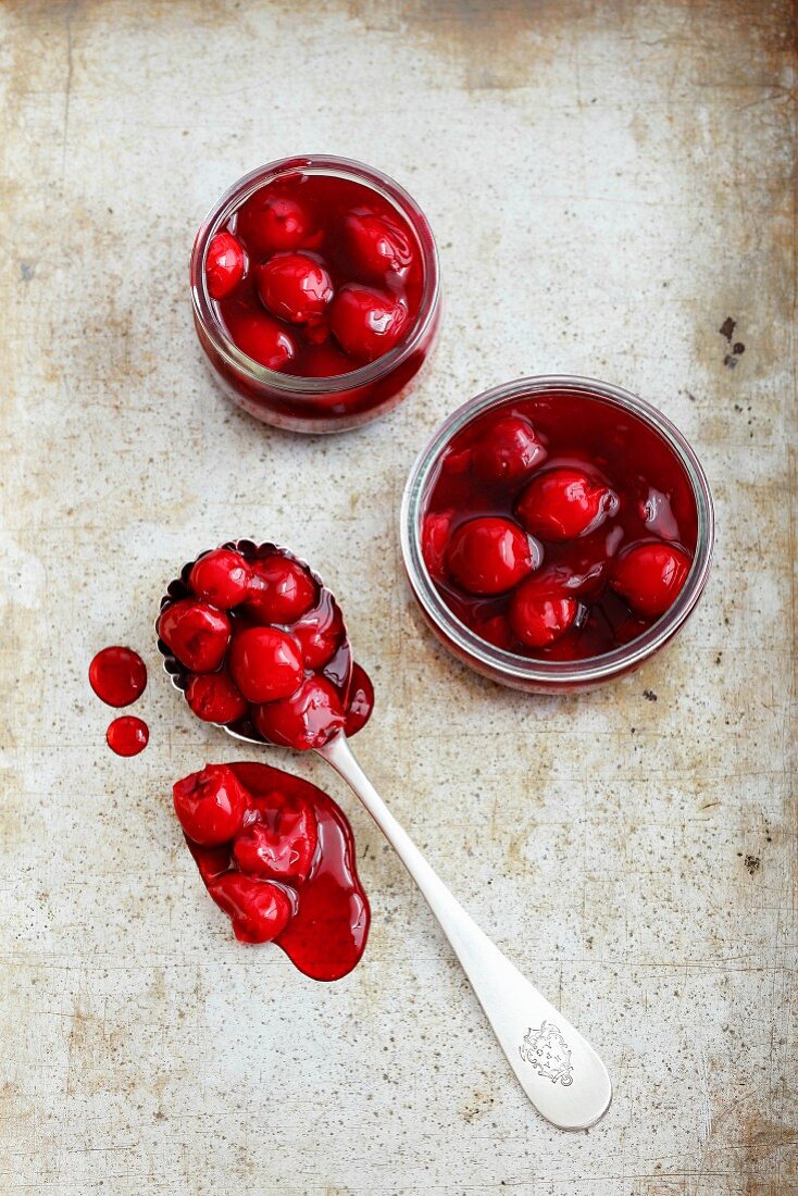Cherry jam in glasses and on a spoon