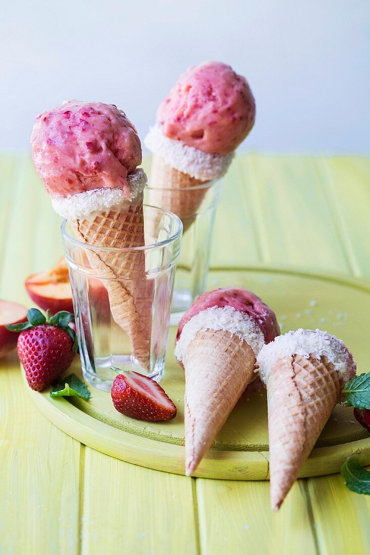 Peach and strawberry frozen yoghurt in chocolate-coconut cones