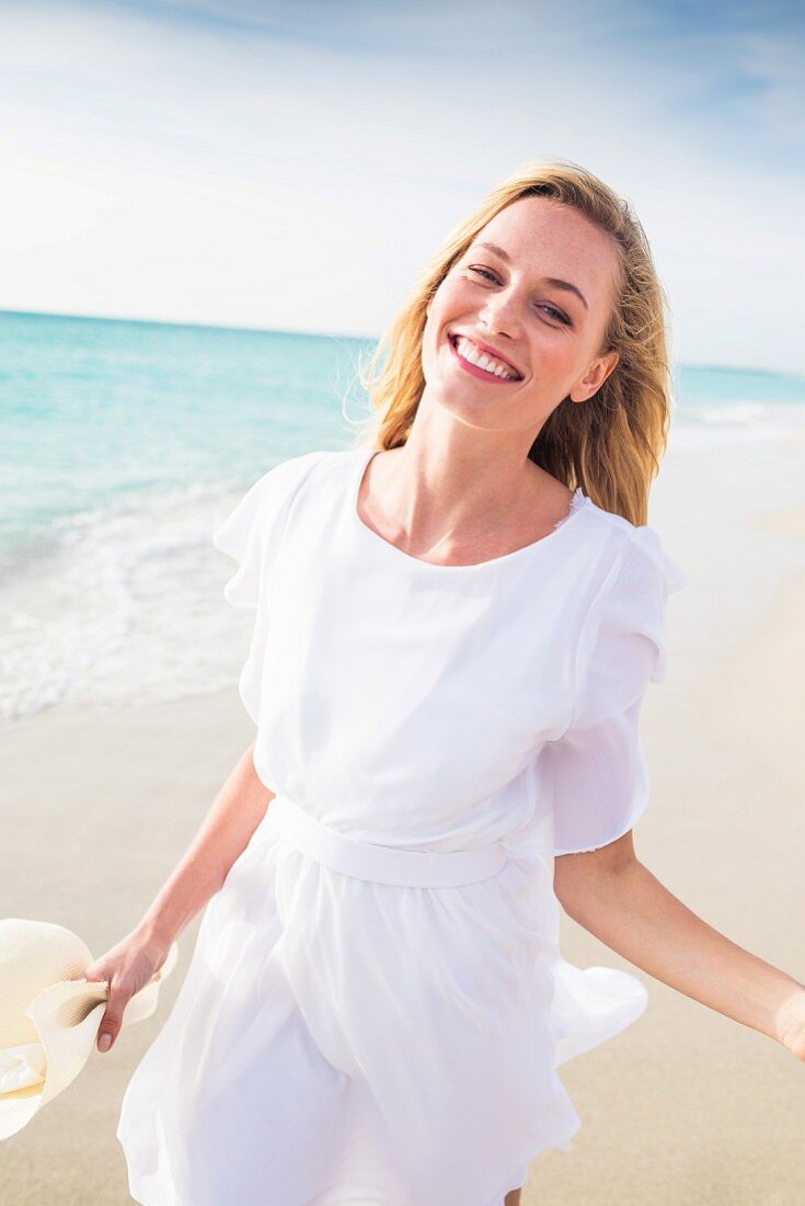 Woman wearing white chiffon dress on beach
