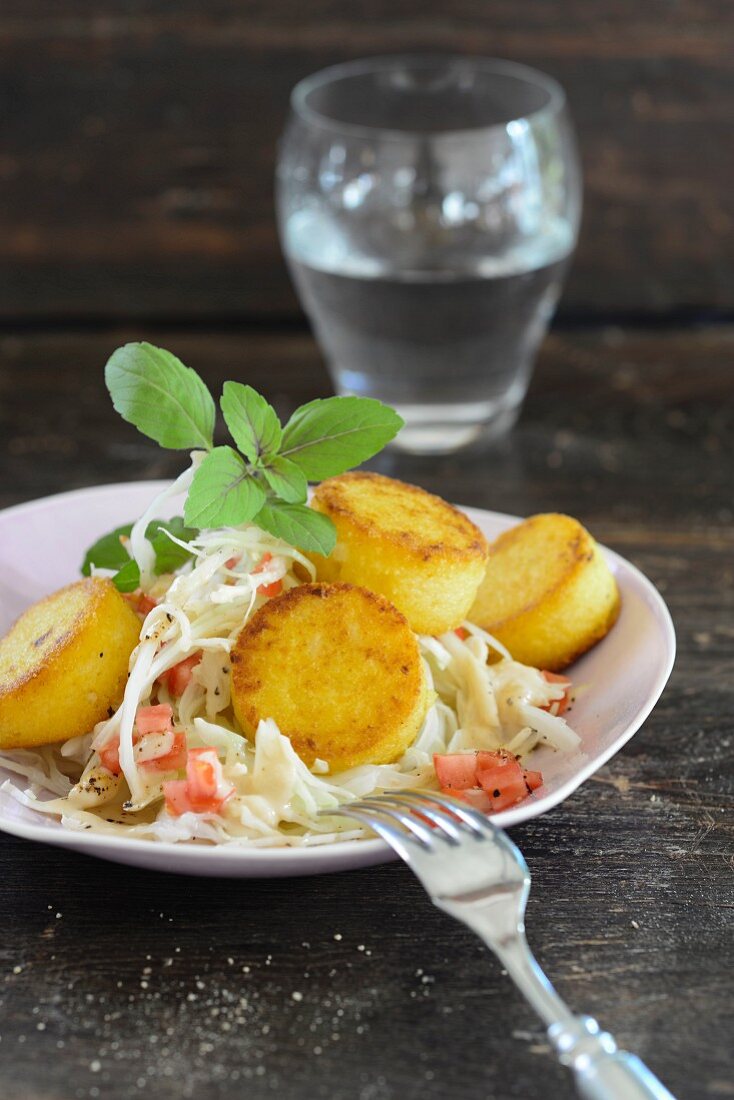 Polenta bites with peanuts and white cabbage