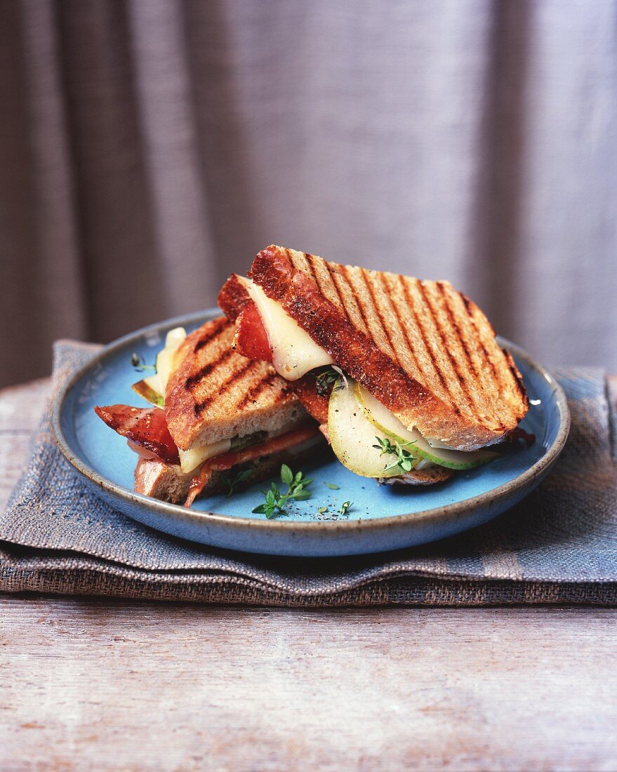 A toasted apple, bacon and cheese sandwich