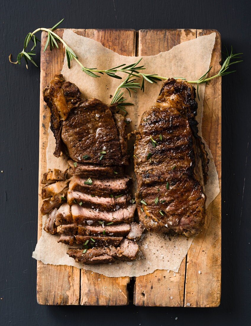 Porterhouse and sirloin steaks on a wooden board