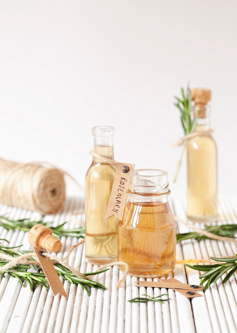 Small bottles of rosemary syrup with fresh rosemary sprigs